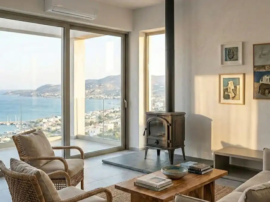Ξυλόσομπα σε φωτεινό σαλόνι με θέα στη θάλασσα